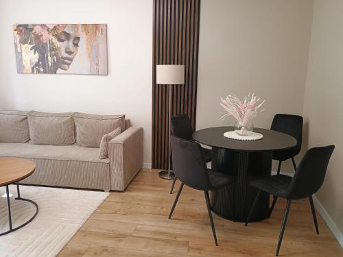 a living room with a table and a couch at Vespera Apartment - Retkinia in Łódź