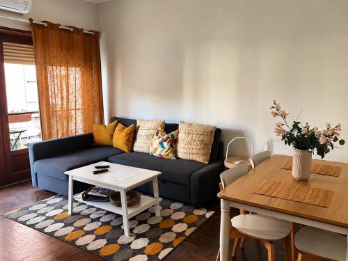 a living room with a blue couch and a table at Lx Factory Apartment-Lisbon Style-Spacious & Bright-Congress Centre in Lisbon