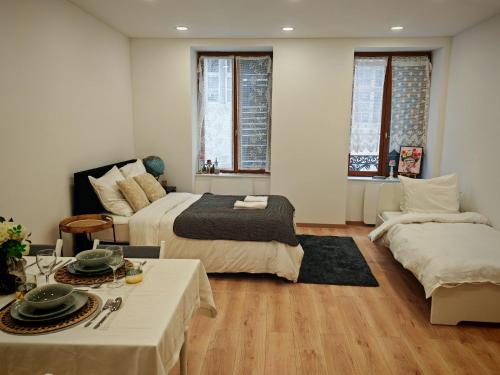 a bedroom with a bed and a table and a couch at Chez Alice 1 in Montbéliard