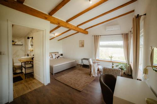 a bedroom with a bed and a desk and a window at Vinewood in Grabrovnik