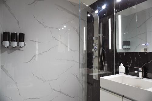 a bathroom with a sink and a shower and a mirror at Viento Sur Anfitrionas "Centro" in Puerto Madryn