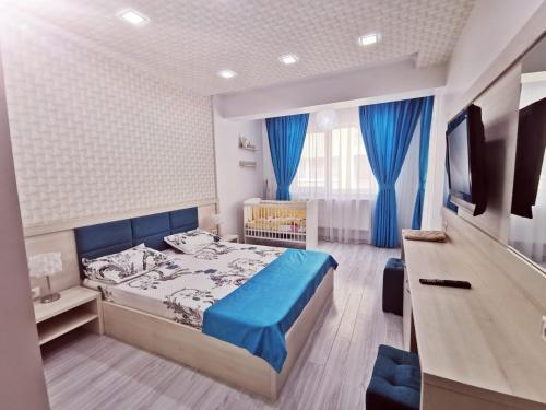 a bedroom with a bed and a crib in it at Promenada 1-4 in Mamaia Sat/Năvodari