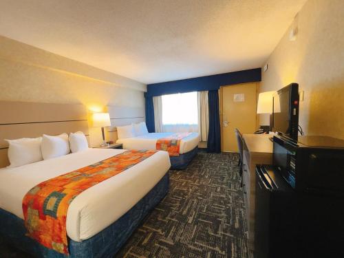 a hotel room with two beds and a flat screen tv at North Vancouver Hotel in North Vancouver