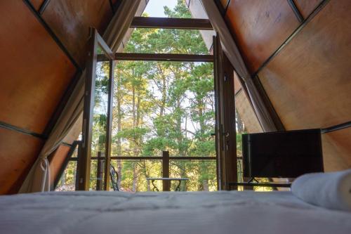 a room with a bed and a large window at Mellmell en la Sierra in Tandil