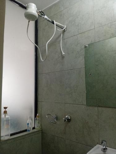 a bathroom with a shower with a mirror and a sink at Victor Airport suites in Nairobi