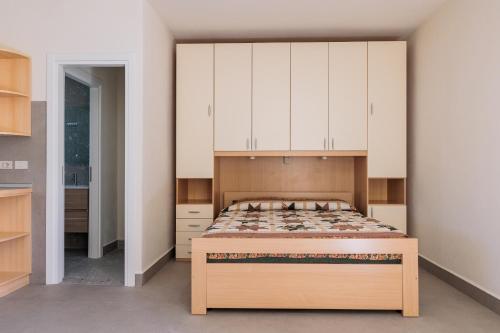 a bedroom with a bed with white cabinets at IL TRITONE in Marina di Bibbona