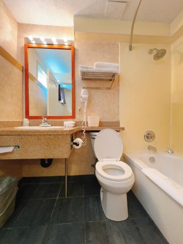 a bathroom with a toilet and a sink and a tub at North Vancouver Hotel in North Vancouver