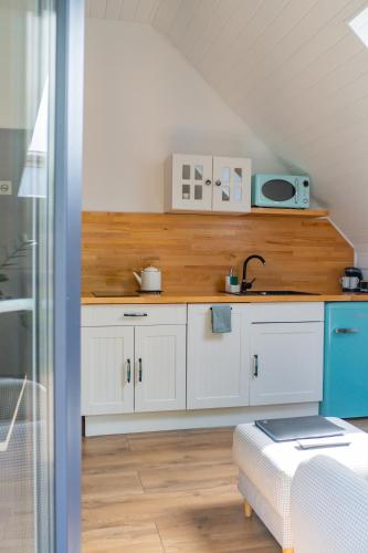 a kitchen with white cabinets and a sink at apartament BB in Podgórzyn