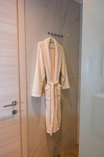 a robe is hanging on a shower door at Omonoia Central Apartment in Kavála