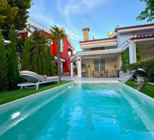 a swimming pool in front of a house at villa MEDITERAN in Pefkochori