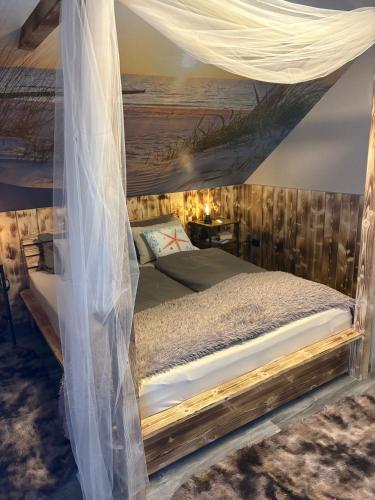 a bedroom with a bed with a mosquito net at Steintor Appartement in Kürten