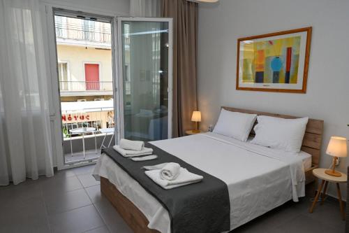 a bedroom with a large bed with towels on it at Omonoia Central Apartment in Kavála