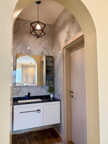 a bathroom with a sink and a mirror at Deluxe Apartment in Muscat
