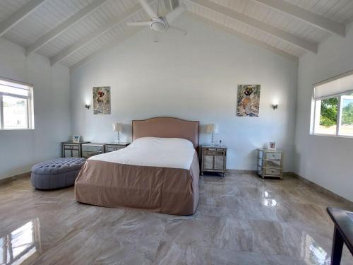 a bedroom with a large bed and two tables at Ocean View Villa with pool in Christ Church