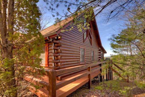 a cabin in the woods with a large wooden deck at Honeys Haven in Morganton