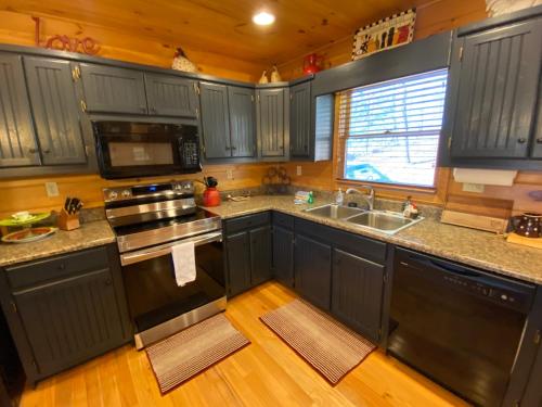 a kitchen with blue cabinets and a sink and a stove at Lallybroch in Morganton