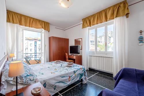 a bedroom with a bed and a tv and windows at Artemisia in Varazze
