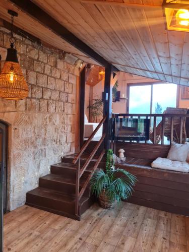 a room with a wooden staircase and a potted plant at Sunny's Suite in Safed