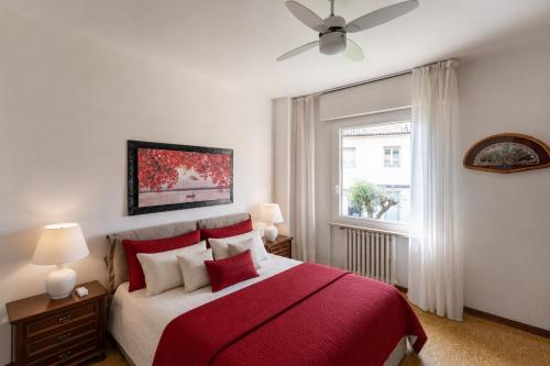 a bedroom with a red and white bed and a window at CASA CARLINA Pet Friendly in Salò