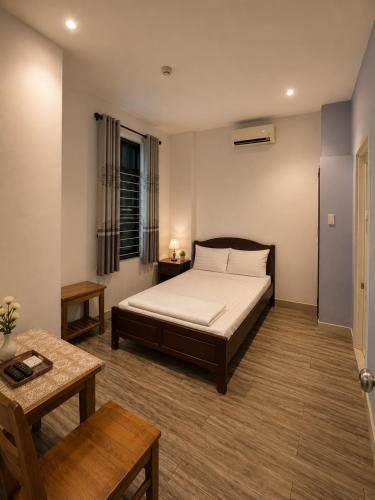a bedroom with a bed and a table at Salyna Motel in Danang