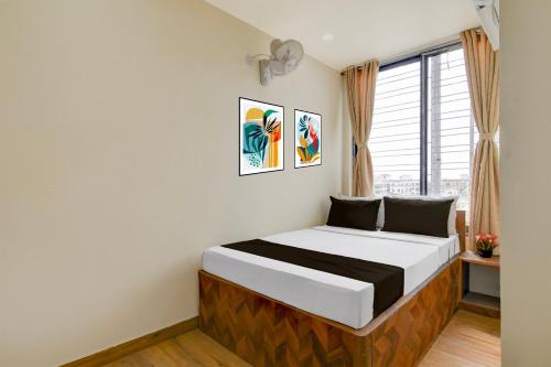 a bedroom with a bed and a window at Hotel O B&B Guest House in kolkata