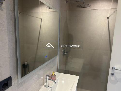 a bathroom with a sink and a mirror at Green Coast 244d - by Ale Investa in Palasë