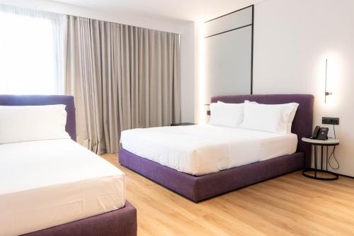 a hotel room with two beds and a couch at Mango Luxury Resorts in Sarandë