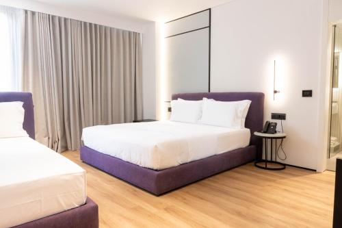 a hotel room with two beds and a table at Mango Luxury Resorts in Sarandë