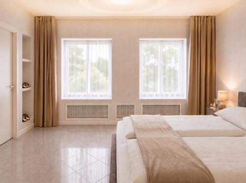 a bedroom with two beds and two windows at Pension Elisa in Rheinfelden