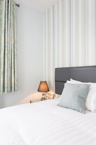a bedroom with a white bed with a pillow and a lamp at The Royal Hotel and Bar in Lancaster