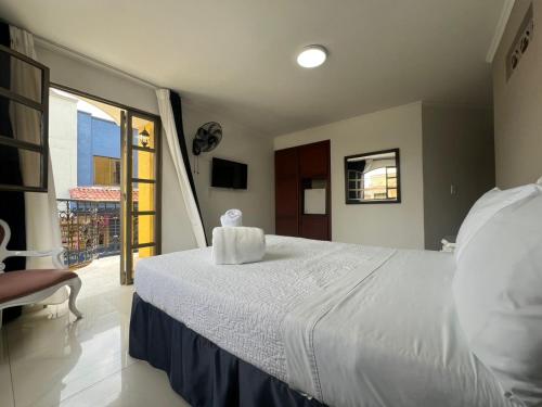 a bedroom with a large white bed and a window at Hotel Suite Santa Rosa in Santa Rosa de Cabal