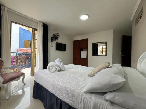 a bedroom with a large bed and a balcony at Hotel Suite Santa Rosa in Santa Rosa de Cabal