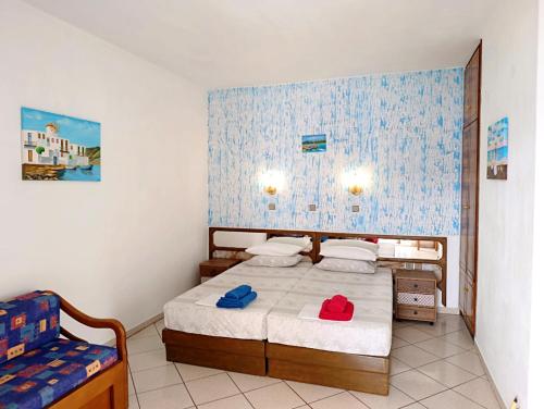 a bedroom with a bed and a chair in it at Studios Maria in Chrysi Ammoudia