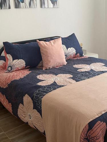 a bed with a blanket and pillows on it at Almaalquiler in Carmen de Patagones