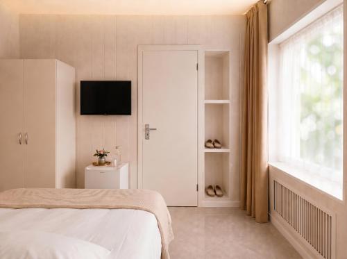 a bedroom with a bed and a television on a wall at Pension Elisa in Rheinfelden