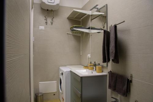 a bathroom with a sink and a washing machine at Open Space Romagna 12 in San Benedetto del Tronto