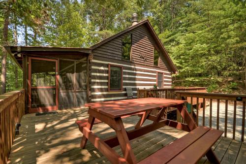 a wooden deck with a picnic table and a cabin at Mountain Retreat in Morganton