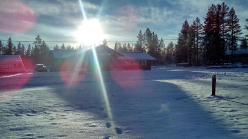 a sun is shining on a snow covered field at Sæteråsen Hytter & Camping Trysil in Trysil