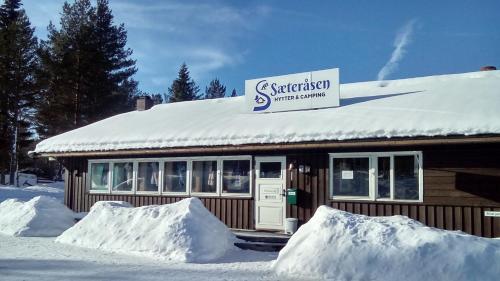 a snow covered building with a sign on top of it at Sæteråsen Hytter & Camping Trysil in Trysil