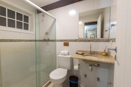 a bathroom with a shower and a toilet and a sink at Pousada Ilha Branca Centro in Búzios