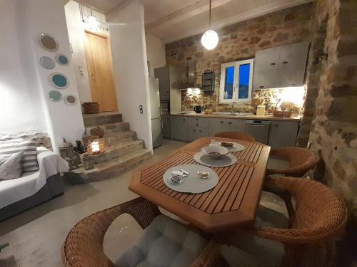 a kitchen with a wooden table and some chairs at il mare stone house with Aegean view in Agios Dimitrios