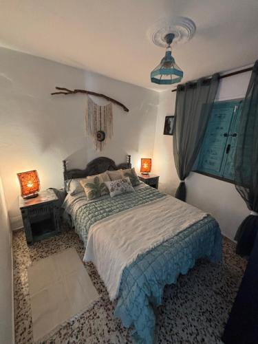 a bedroom with a bed and two lamps in it at La casita de Denis in Periana