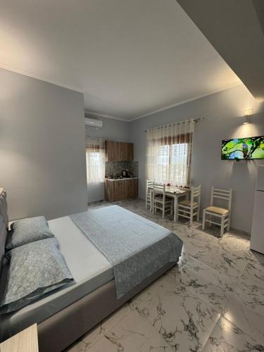 un dormitorio con una cama grande y una mesa en Mesaiz, en Vlorë