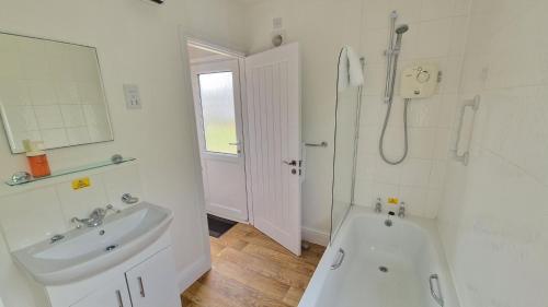 a bathroom with a sink and a tub and a shower at 3 The Burrows in Braunton