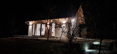 a small white house at night with lights at Udahni prirodu - Panorama in Raška