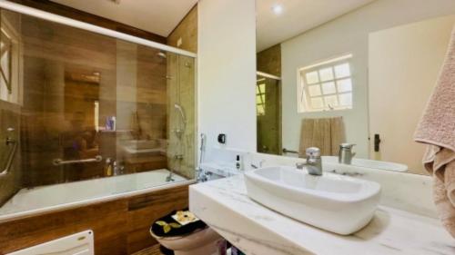 a bathroom with a sink and a shower and a tub at Hotel dos Príncipes - Guarujá in Guarujá