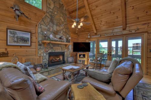 a living room with leather furniture and a stone fireplace at Storybook in Morganton