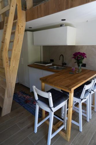 a kitchen with a wooden table and two white chairs at Udahni prirodu - Panorama in Raška