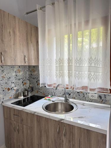 una encimera de cocina con fregadero y ventana en Mesaiz, en Vlorë