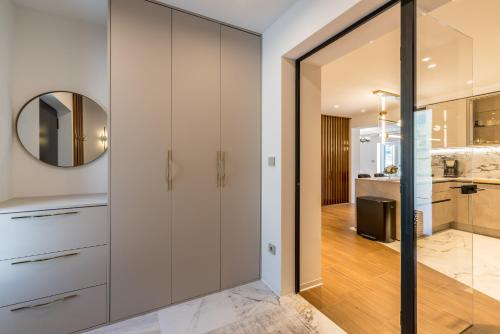 a kitchen with white cabinets and a mirror at Countryside family villa with pool Zmina in Donji Muć